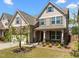 Two-story home featuring stone accents, shuttered windows, a cozy front porch, and a manicured lawn at 1033 Laredo Ln, Durham, NC 27703