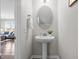 Elegant powder room with pedestal sink, oval mirror, and decorative accents at 1033 Laredo Ln, Durham, NC 27703