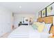 Bright bedroom with a wooden headboard, striped linens and colorful pillows, creating a relaxing and inviting atmosphere at 104 Red Maple St, Sanford, NC 27332