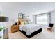 Bright bedroom features a comfortable bed, decorative pillows, and a large window dressed with patterned curtains at 104 Red Maple St, Sanford, NC 27332