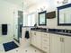 Bright bathroom with glass shower, double vanity with blue countertops, and modern lighting at 105 Hein Dr, Clayton, NC 27527