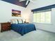 Comfortable bedroom features carpet, natural light from the window, and complemented with a beautiful accent painting at 105 Hein Dr, Clayton, NC 27527
