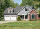 Two-story home with a well-manicured lawn, dormer windows, and two car garage at 105 Hein Dr, Clayton, NC 27527