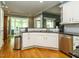 Open-concept kitchen with white cabinets, stainless steel appliances, and hardwood floors at 105 Hein Dr, Clayton, NC 27527