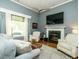 Cozy living room featuring a fireplace, comfortable seating, and large windows at 105 Hein Dr, Clayton, NC 27527