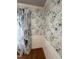 Room featuring decorative wallpaper, white wainscoting, hardwood floors, and elegant window treatments at 105 Hein Dr, Clayton, NC 27527