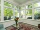 Bright sunroom featuring large windows, a cozy seating area, and serene outdoor views at 105 Hein Dr, Clayton, NC 27527