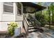 Back porch with brown railings, stairs, ceiling fan, and small potted plants at 107 Deer St, Carrboro, NC 27510