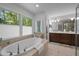 Bright bathroom featuring a large soaking tub with natural light and a double vanity at 107 Deer St, Carrboro, NC 27510
