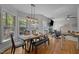 Dining area featuring large windows, a wooden table with seating, and a modern light fixture, adjacent to the living area at 107 Deer St, Carrboro, NC 27510