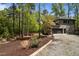 Attractive home with a two-car garage, well-kept landscaping, and a gravel driveway surrounded by mature trees at 107 Deer St, Carrboro, NC 27510