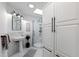 Bright bathroom with a walk-in shower, a pedestal sink, and white cabinets at 10805 The Olde Pl, Raleigh, NC 27614