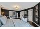 Bedroom with dark accent walls, hardwood floors, and french doors to an outdoor seating area at 10805 The Olde Pl, Raleigh, NC 27614