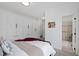 Bright bedroom showcasing white walls and cabinetry, with a bed dressed in neutral tones and textures at 10805 The Olde Pl, Raleigh, NC 27614