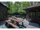 Wooden deck with rustic dining table and seating, overlooking private backyard and screened porch at 10805 The Olde Pl, Raleigh, NC 27614