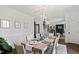 Elegant dining room features modern chandelier, a long wooden table set for a meal, and views of the living spaces at 10805 The Olde Pl, Raleigh, NC 27614