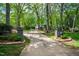 Long concrete driveway leading up to the home’s entrance and surrounded by mature trees at 10805 The Olde Pl, Raleigh, NC 27614