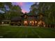 Elegant two-story home featuring arched windows and lush landscaping, lit by an inviting sunset at 10805 The Olde Pl, Raleigh, NC 27614