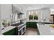 Well-appointed kitchen features professional-grade appliances, green lower cabinets, and ample counter space at 10805 The Olde Pl, Raleigh, NC 27614