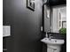 Elegant powder room features a sleek design with modern fixtures and dark walls at 10805 The Olde Pl, Raleigh, NC 27614