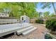A backyard deck with bench seating, a patio, an outdoor storage unit and beautiful landscaping at 120 Barbary Ct, Cary, NC 27511