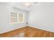 Bright bedroom with hardwood floors, ceiling fan, and a large window offering ample natural light at 120 Barbary Ct, Cary, NC 27511