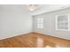 Bedroom with hardwood floors, neutral paint, and two windows at 120 Barbary Ct, Cary, NC 27511