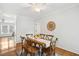 Bright dining room boasts hardwood floors, decorative rug, rustic table with six chairs and a ceiling fan at 120 Barbary Ct, Cary, NC 27511