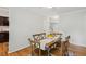 Well-lit dining room featuring hardwood floors, a decorative rug, a rustic table with six chairs at 120 Barbary Ct, Cary, NC 27511