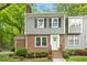 Charming townhouse with a brick facade, gray siding, black shutters, and landscaped front yard at 120 Barbary Ct, Cary, NC 27511
