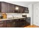 Well-lit kitchen featuring stainless steel appliances, dark cabinets, light countertops, and hardwood floors at 120 Barbary Ct, Cary, NC 27511