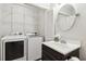 Convenient laundry area with washer, dryer, wire shelving, a sink, and storage space at 120 Barbary Ct, Cary, NC 27511