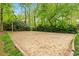 Community sand volleyball court surrounded by mature trees, perfect for outdoor recreation at 120 Barbary Ct, Cary, NC 27511