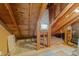 Unfinished attic space with exposed wooden beams, a window, and flooring at 1234 Shadowbark Ct, Raleigh, NC 27603