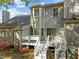 Back exterior showcasing a wooden deck with stairs, complimented by blooming shrubs and mature landscaping at 1234 Shadowbark Ct, Raleigh, NC 27603