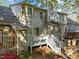 Back exterior showcasing a wooden deck with stairs, complimented by blooming shrubs and mature landscaping at 1234 Shadowbark Ct, Raleigh, NC 27603