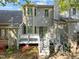 Back exterior showcasing a wooden deck with stairs, complimented by blooming shrubs and mature landscaping at 1234 Shadowbark Ct, Raleigh, NC 27603