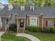 Inviting brick townhome with dormer windows, well-maintained lawn, and walkway to the front entrance at 1234 Shadowbark Ct, Raleigh, NC 27603