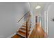 Hallway with hardwood floors and staircase. A glimpse into the living room with fireplace at 1234 Shadowbark Ct, Raleigh, NC 27603