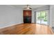 Bright living room featuring hardwood floors, a fireplace, and glass doors to the deck at 1234 Shadowbark Ct, Raleigh, NC 27603