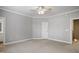 A neutral bedroom with a ceiling fan and carpet at 126 W Savannah Ridge Rd, Holly Springs, NC 27540