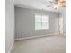 Spacious bedroom with plush carpet, natural light, and a ceiling fan at 126 W Savannah Ridge Rd, Holly Springs, NC 27540