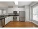 Modern kitchen featuring white cabinets, stainless steel appliances, and hardwood floors at 126 W Savannah Ridge Rd, Holly Springs, NC 27540