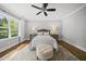 Cozy bedroom featuring a plush rug, ottoman, and a large window for natural light at 1306 Mordecai Dr, Raleigh, NC 27604