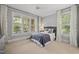 Stylish bedroom featuring a large window with shutters, stylish curtains, and a ceiling fan at 1306 Mordecai Dr, Raleigh, NC 27604