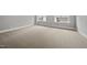 Spacious bonus room featuring neutral carpet, white trim, and two large windows with natural light at 1306 Mordecai Dr, Raleigh, NC 27604