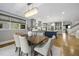 Elegant dining area with a wooden table, chandelier, and an open view to the modern kitchen at 1306 Mordecai Dr, Raleigh, NC 27604