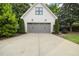Exterior view of a modern detached garage with gray doors and well-maintained landscaping at 1306 Mordecai Dr, Raleigh, NC 27604