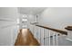 Hallway with wood flooring and white staircase leading to the second floor at 1306 Mordecai Dr, Raleigh, NC 27604