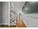 Hallway with hardwood floors and white staircase leading to upstairs at 1306 Mordecai Dr, Raleigh, NC 27604